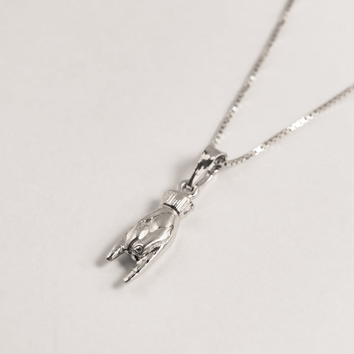 A close up view of Qrun silver Lucky Charm Pendant. 