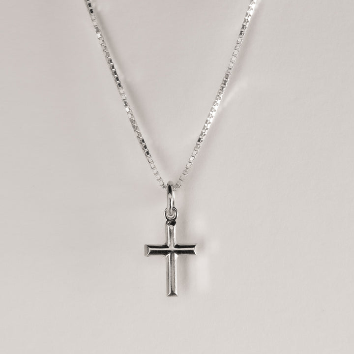 A close up view of Silver Embossed Cross Pendant. 