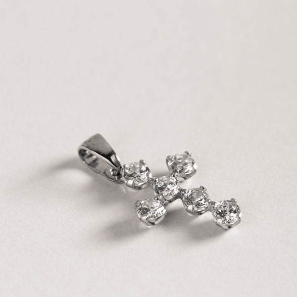 A silver-colored zirconia cross pendant on a plain background.