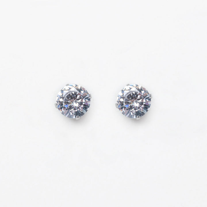 A close up view of Solitaire Silver Stud Earrings standing in the center of the image. 