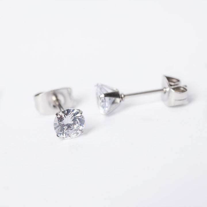 A close up view of Solitaire Silver Stud Earrings standing in the center of the image against a white background. 