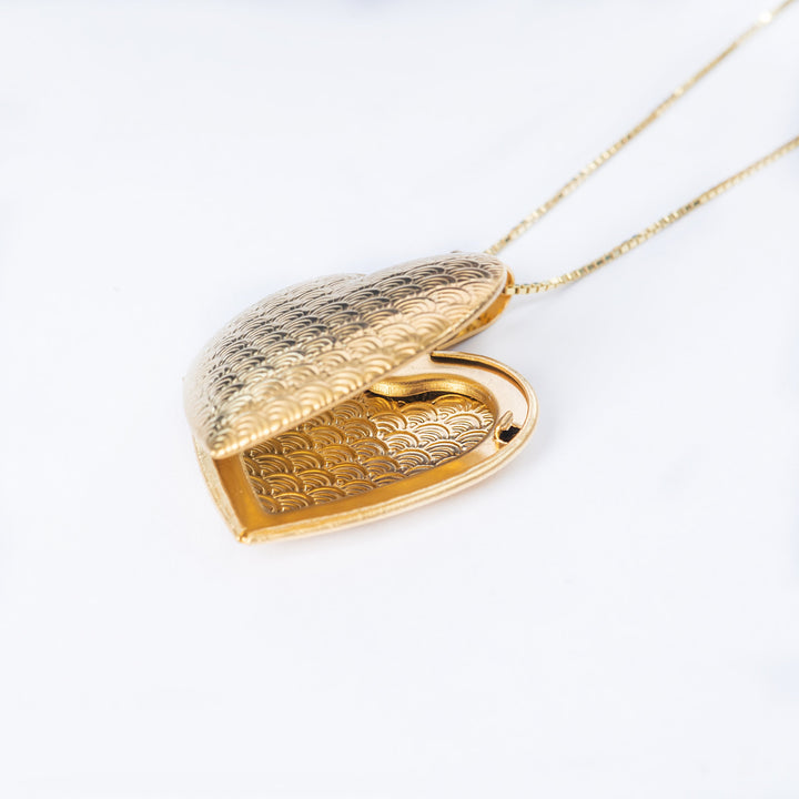 A close up view of Sweet Heart Locket standing in the center of the image with its chain coming from the upper right angle. 