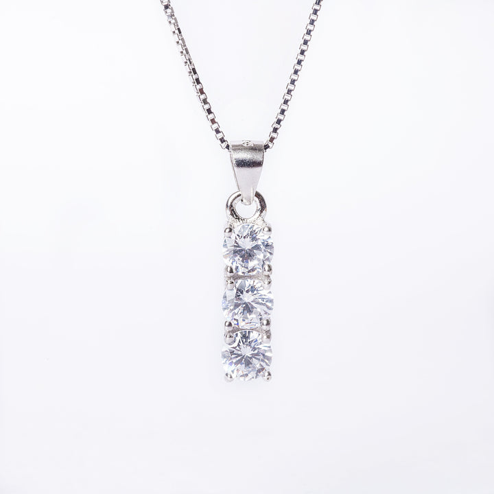 A close up view of Trilogy Necklace standing in the center of the image against a white background. 