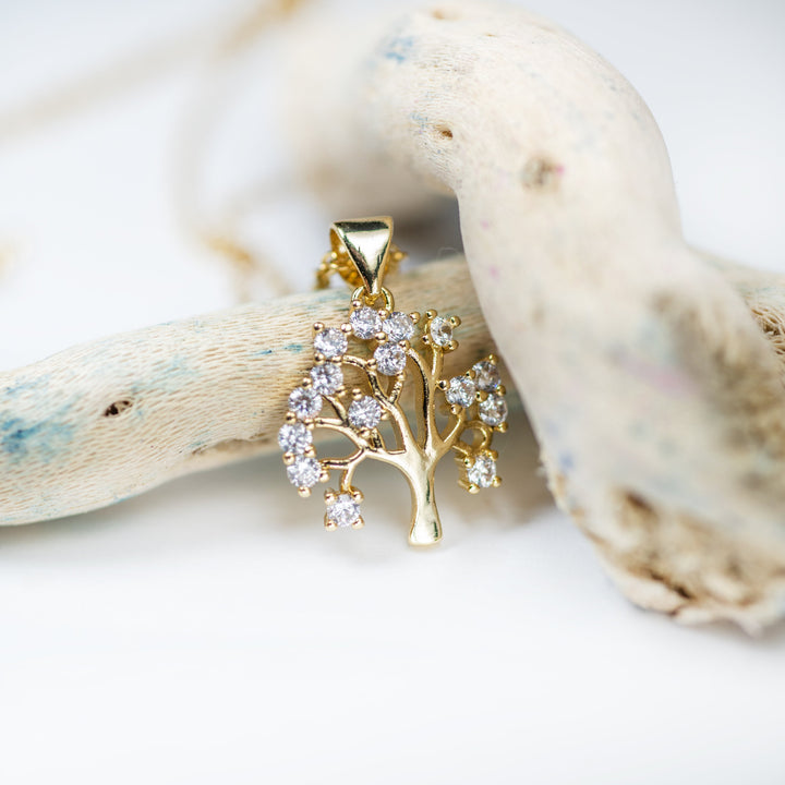 A close up view of Tree Of Life Necklace standing in the center of the image against a white background. 