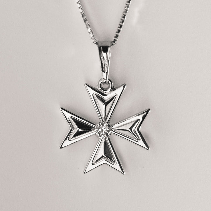 A silver Maltese cross necklace with a central cubic zirconia surrounded by smaller clear crystals on a silver chain.