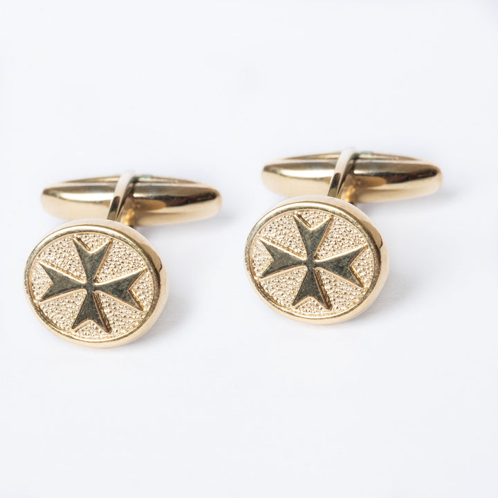 A close up view of Xandru Gold cufflinks standing in the center of the image against a white background. 