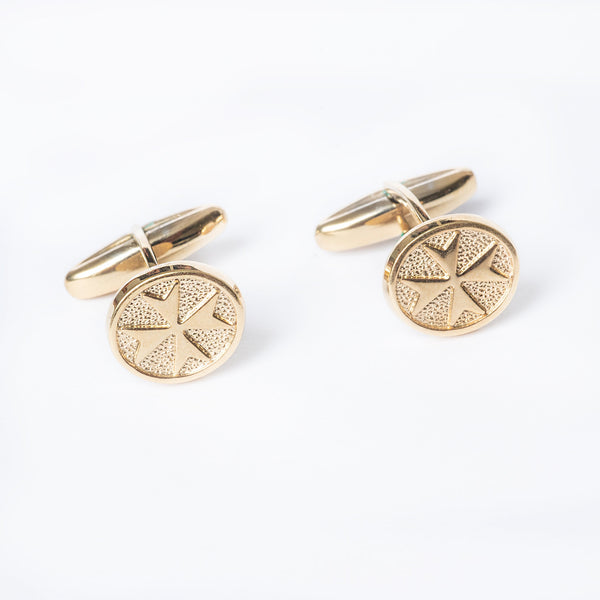 A pair of gold-plated Xandru cufflinks with a geometric pattern on the center, on a white background.