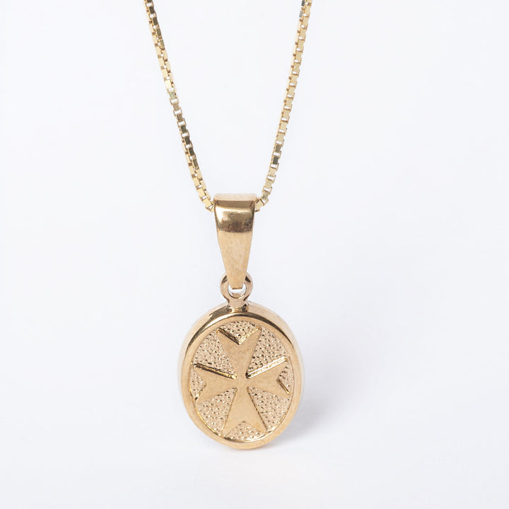 A close up view of Xandru Gold pendant standing in the center of the image against a white background. 