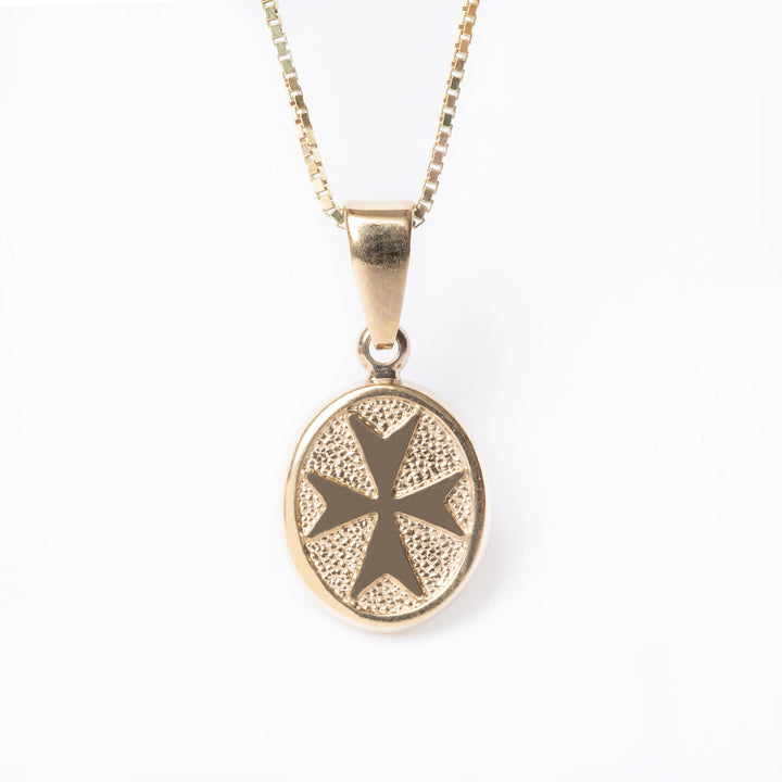 Xandru Gold pendant standing in the center of the image. 